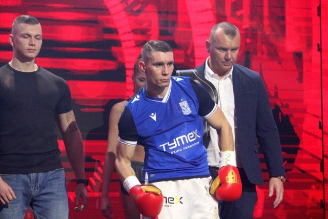 Damian Wrzesiński obronił pas zawodowego mistrza PolskiW Szydłowcu odbyła się 14 gala Tymex Boxing Night. W walce wieczoru Damian Wrzesiński wyraźnie, jednogłośnie wygrał z Meksykaninem, Luisem Angelem „Bofo” Viedasem (26-9-1, 9 KO). Jeszcze do szóstej rundy rywal Wrzesińskiego trzymał się nieźle, ale potem starał się już przede wszystkim bronić i mocno stać na nogach. - Zacząłem tą walkę nerwowo, aby przede wszystkim nie popełnić błędu, bo w boksie wystarczy czasem jeden błąd, aby doznać porażki. Potem z czasem było coraz lepiej. Na ringu ostatecznie odbyło się sześć pojedynków zamiast ośmiu. Nie zobaczyliśmy w akcji zawodnika z Szydłowca, Mateusza Rycerskiego, który w piatek borykał się z gorączką i ostatecznie jego debiutancki pojedynek z Piotrem Kuberskim odwołano. Nie odbył się też pojedynek Tomasza Gromadzkiego z Marianem Dziupką. Ten ostatni otrzymał pozytywny test na obecność koronawirusa. Mimo sześciu pojedynków emocji było sporo. Łukasz Maciec po dwuletniej przerwie wrócił do ringu i pokonał Czecha, Marka Andryska, niejednogłośnie 79-73, 78-74, 75-77. Stanisław Gibadło (5-0, 0 KO) bardzo pewnie poradził sobie z Damianem Stanisławskim (4-1, 1 KO). Oskar Kapczyński (4-1, 2 KO) pokonał doświadczonego kickboksera Marcina Piegońskiego (1-1, 0 KO), a na początek gali Błażej Nowak wygrał na punkty z Vladymirem Jaszynem, zaś Adam Górski wygrał z Łukaszem Załuską na punkty 2 do remisu.  W Tymex Boxing Night w Szydłowcu brakowało trochę efektownych nokautów i...kibiców. Galę ze zrozumiały względów oglądała garstka zaproszonych gości. Imprezę pokazywał kanał TVP Sport. ZOBACZ KOLEJNE ZDJĘCIA Z WALK, KTO SIEDZIAŁ POD RINGIEM ====>>>