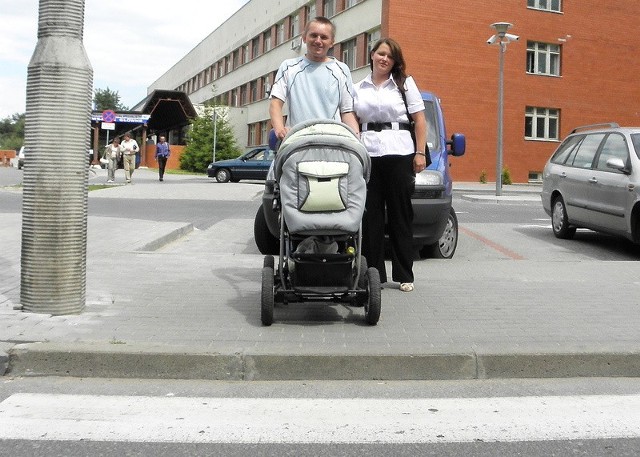 Aleksandra Wiśniewska i Dawid Bugalski z wózkiem, przed krawężnikiem na przejściu przy przychodniach specjalistycznych