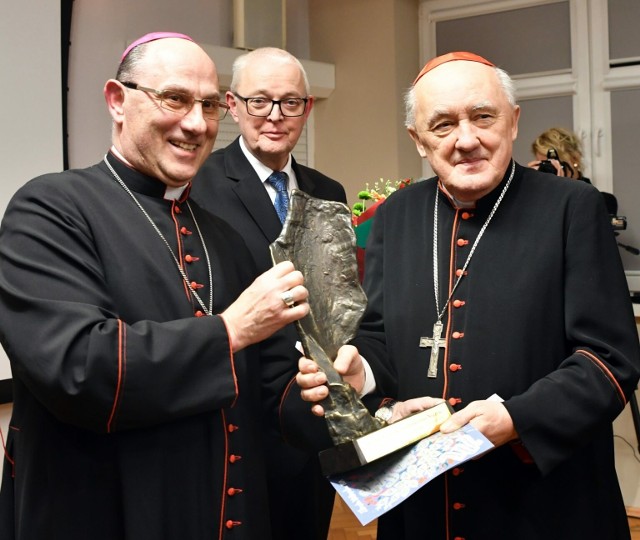 Kardynał Kazimierz Nycz przyjmuje z rąk prymasa Wojciecha Polaka statuetkę "Ku chwale". W środku pełniący funkcję prezydenta Inowrocławia Wojciech Piniewski