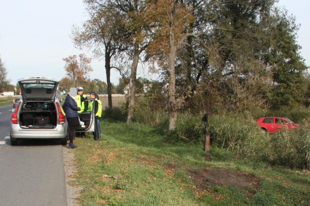 Policjanci przesłuchują świadków wypadku w Orońsku. W tle volkswagen golf, który dachował.