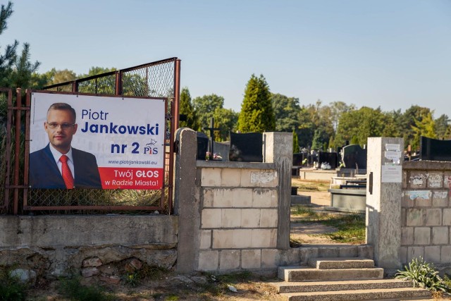 Plakat wyborczy z wizerunkiem Piotra Jankowskiego z PiS wisi na ogrodzeniu cmentarza żydowskiego