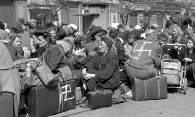 Niemcy czekają na transport za  Odrę w jednym z miast, które po 1945 roku przypadły Polsce (niektórzy zostali oznaczeni swastyką). Duża ich część nigdy nie wyjechała, bo padła ofiarą mordów dokonanych przez sowieckich żołnierzy