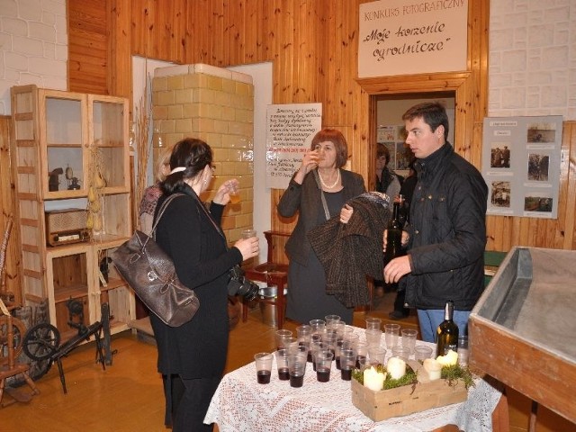 Marceli Małkiewicz częstuje uczestników  spotkania w obrazowskiej Izbie Tradycji Ogrodniczych winem oraz cydrem własnej, „próbnej” produkcji.