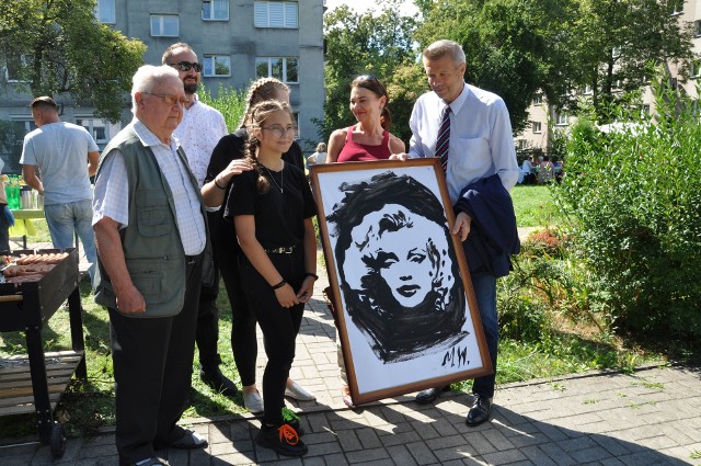 W ogrodzie Klubu Seniora przy ulicy świętego Stanisława Kostki odbyło się wyjątkowe spotkanie. Uczestniczyli w nim prezydent Kielc Bogdan Wenta z żoną Iwoną oraz seniorzy z pięciu Klubów Seniora. Spotkanie było kontynuacją wieloletniej współpracy pomiędzy kieleckimi Klubami Seniora oraz Klubem Młodzieżowym Wolna Strefa. Takie wydarzenia mają na celu integrację międzypokoleniową, dzięki której dzieci mogą poznać potrzeby osób starszych oraz zobaczyć jak aktywnie i radośnie spędzają swój czas wolny podczas wspólnego grillowania. Uczestnicy kieleckich Klubów Seniora mogli podzielić się swoimi doświadczeniami i miło spędzić czas z młodzieżą. Podczas spotkania były też atrakcje sportowe, muzyka z lat 60-tych, wręczenie obrazu dla prezydenta Bogdana Wenty i jego żony Iwony. Obraz namalowały dzieci, a seniorzy w pracowni stolarskiej oprawili w ramę. - Podczas spotkania gościliśmy pana prezydenta Bogdana Wentę z żoną Iwoną, co sprawiło dużą przyjemność naszym seniorom, jak również dzieciom. Wszyscy mogli porozmawiać z panem prezydentem oraz zrobić sobie pamiątkowe zdjęcia. Dzieci z kierownikiem Młodzieżowego Klubu  Martyną Wrońską zapewniły atrakcje artystyczne - występ wokalny oraz malowanie obrazów. Wszyscy byliśmy pod ogromnym wrażeniem talentów naszych młodych przyjaciół i bardzo się cieszymy, że wszystko tak pięknie się udało. Bardzo dziękuję wszystkim za obecność i mam nadzieję, że w przyszłości będziemy mogli robić więcej tego typu spotkań integracyjnych - powiedział Piotr Płoskonka, kierownik Klubu Seniora przy ulicy Kostki. Szczegóły na kolejnych slajdach. (dor)