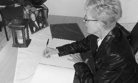 Elżbieta Wasiak wpisuje się do księgi kondolencyjnej