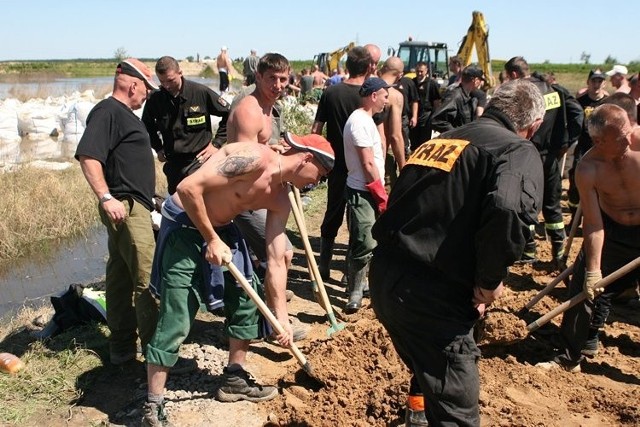 Pojemniki na piach napełniali osadzeni z zakładu karnego wspólnie ze strażakami.