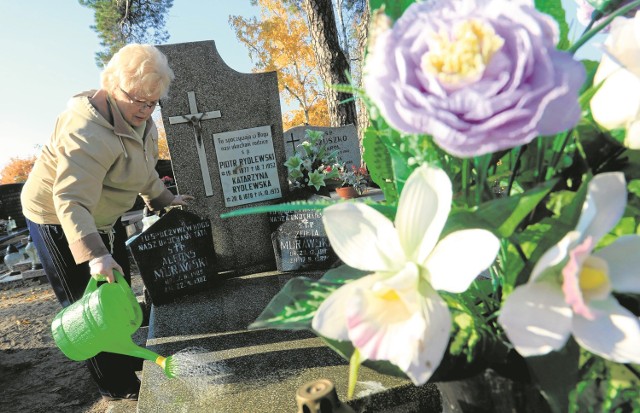 Maria Murawska porządkuje grób na Cmentarzu Komunalnym w Toruniu 