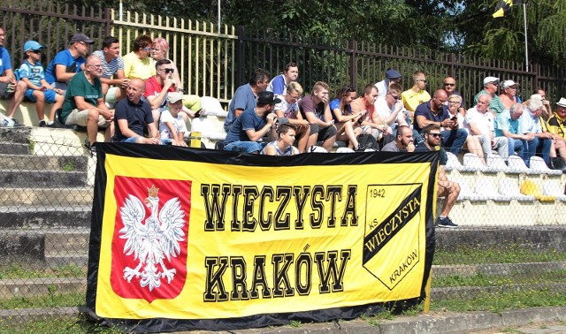 Na ławce trener z doświadczeniem na szczeblu centralnym, a w składzie zawodnicy z przeszłością w Ekstraklasie czy 1 lidze. W Krakowie bez wątpienia rośnie nowa siła. Drużyna nazywa się Wieczysta i ma hojnego sponsora, Wojciecha Kwietnia, którego ambicje sięgają tak wysoko, jak stacjonującej nieopodal Bruk-Bet Termaliki Nieciecza. Zobaczcie, kim obecnie w lidze okręgowej (szósty poziom rozgrywkowy!) dysponuje Wieczysta - lider okręgowej grupy Kraków II (cztery zwycięstwa, remis, bilans bramkowy 16-3).