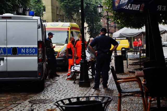 W środę 52-latka zmarła w deszczu, siedząc na ławce przy ul. Nowobramskiej w Słupsku. Nie jest wykluczone, że zanim upadła, przez kilka godzin siedziała po śmierci, a ludzie przechodzili  obok niej.  Wezwany na miejsce patrol policji i lekarz pogotowia, stwierdzili zgon kobiety. Jak ustaliła policja, śmierć kobiety nastąpiła z przyczyn naturalnych i nie stwierdzono udziału osób trzecich.Od Klaudiusza Dyjasa, dyrektora Miejskiego Ośrodka Pomocy Rodzinie w Słupsku dowiedzieliśmy się, że 52-letnia kobieta przyjechała do Słupska z województwa zachodniopomorskiego. Tu tylko raz skorzystała ze świadczenia pomocy społecznej. Poza tym nadużywała alkoholu. Po jej śmierci MOPR skontaktował się z córką zmarłej, która ma zdecydować, czy pokryje koszty pogrzebu.    