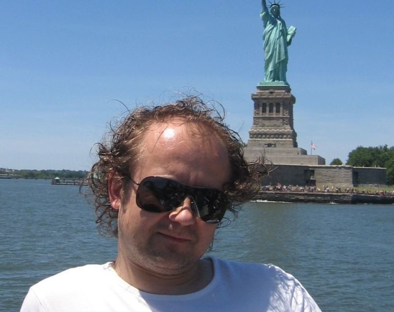 Piotr Sznajder w Nowym Jorku; w tle Statua Wolności.