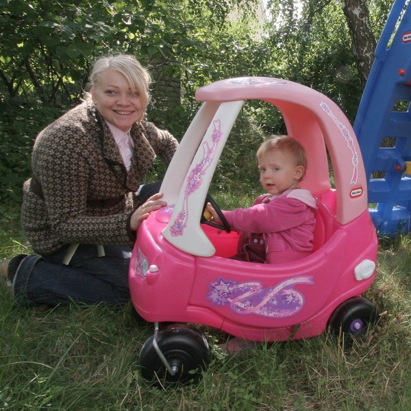 Monika Kuźnicka bawi się z dzieckiem w przedszkolnym ogrodzie.