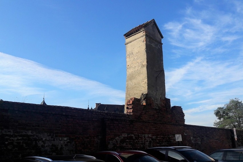 Wieżyczka wodociągowa wznosząca się nad murami miejskimi...