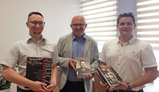 Książki przekazane dla biblioteki w Tuczępach odebrał wójt Marek Kaczmarek (w środku), z rąk Adriana Szczerby (z lewej) i Łukasza Chodóra z Ponidziańskiego Stowarzyszenia Tukidydes.