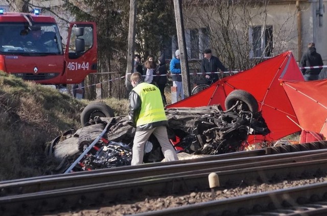 Do wypadku na przyjeździe strzeżonym w miejscowości Dziarnowo doszło dzisiaj około godziny 7.30. Rozpędzony pociąg pośpieszny relacji Poznań-Gdynia uderzył w znajdujące się na przejeździe audi. - W wyniku uderzenia pociągu w auto zginęły dwie osoby. Poniosły śmierć na miejscu - mówi starszy aspirant Izabella Drobniecka, oficer prasowy Komendy Powiatowej Policji w Inowrocławiu. - Ofiary to 23-letnia kobieta i jej krewny. Jak ustaliliśmy , mężczyzna to prawdopodobnie ojciec 23-latki. Na miejscu trwa akcja policji i straży pożarnej. Służby ustalają, jak doszło do wypadku. Wyjaśniają, jak to możliwe, że wypadek miał miejsce, choć dostępu do przejazdu w tym miejscu bronią szlabany. - Czy szlabany był podniesione, kiedy auto wjechało na przejazd? - pytamy policję. - To jest właśnie przedmiotem naszych ustaleń - odpowiada krótko Drobniecka. Ruch na przejeździe, na którym doszło do tragedii, został już wznowiony. Przywrócono drożność jednego toru. Ruch odbywa się tak wahadłowo. Opóźnienia w pociągach, których trasa przebiega przez przejazd, wahają się od kilkunastu minut do godziny. Pasażerowie zostali przesadzeni do podstawionych busów. Ze wstępnych informacji wynika, że dróżnik był trzeźwy. Zgodnie z decyzją prokuratora z Inowrocławia, 41-letni dróżnik został zatrzymany do wyjaśnienia. Mężczyzna trafił do policyjnego aresztu. Dalsze decyzję związane z jego losem podejmować będzie prokurator.(mc)Wideo: Rafał Frydrych