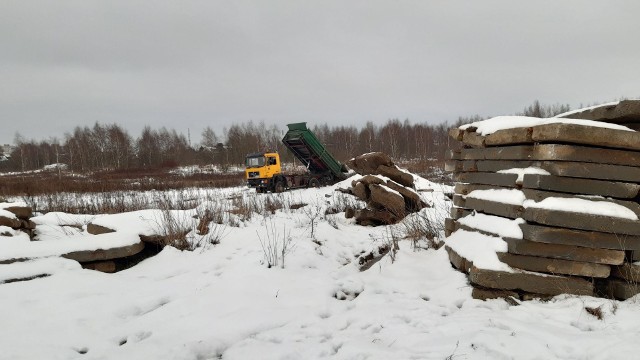 Ciężki sprzęt niszczy ulicę Korfantego, która wyłożona jest kostką brukową.