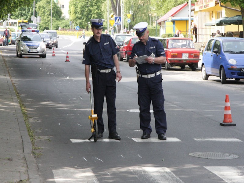 Policjanci mierzą drogę hamowania motocyklisty.