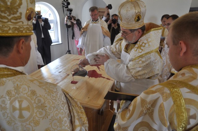 Biskup Włodzimierz Juszczak dokonuje obmycia winem ołtarza w cerkwi