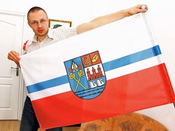 Rzecznik prezydenta Michał Kujaczyński z obowiązująca od niedawna flagą Kołobrzegu. W jej centrum znajduje się herb miasta (tu niestety odwrócony na lewą stronę).