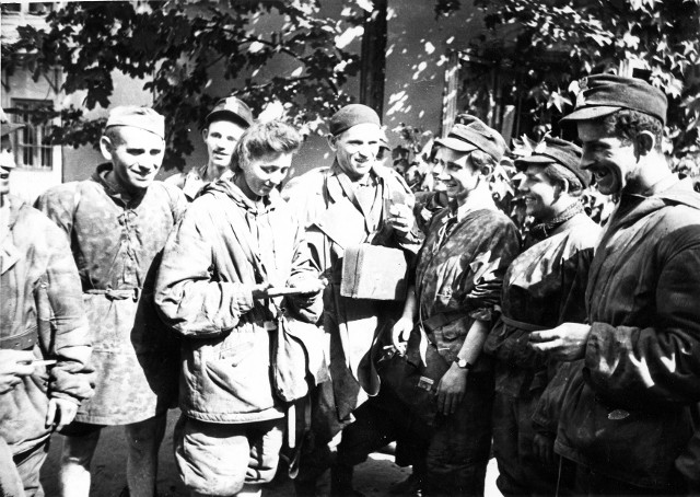 Grupa powstańców ze Starówki odpoczywa po ewakuacji kanałami na jednej z posesji przy ul. Wareckiej. Śródmieście Północne. 1 września 1944 r.