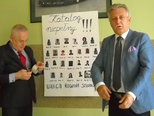 Starosta z pomocą sekretarza urzędu Zdzisława Barana (z lewej)  zawiesza rodzinne zdjęcia.