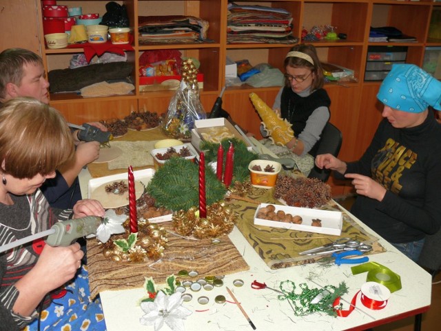 Uczestnicy warsztatów wykonują stroiki świąteczne.