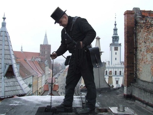 Dariusz Ziółkowski, mistrz kominiarski  czyści komin dachu kamienicy w centrum Chełmna