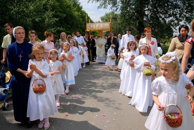 Baranów Sandomierski. Przed Najświętszym Sakramentem dziewczynki w białych sukienkach sypią płatki kwiatów.