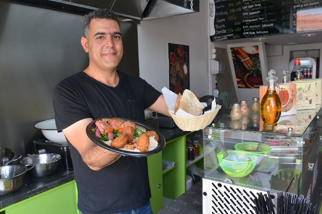 Husein Fettel, współwłaściciel Falafel Maya prezentuje arabski przysmak serwowany w lokalu.