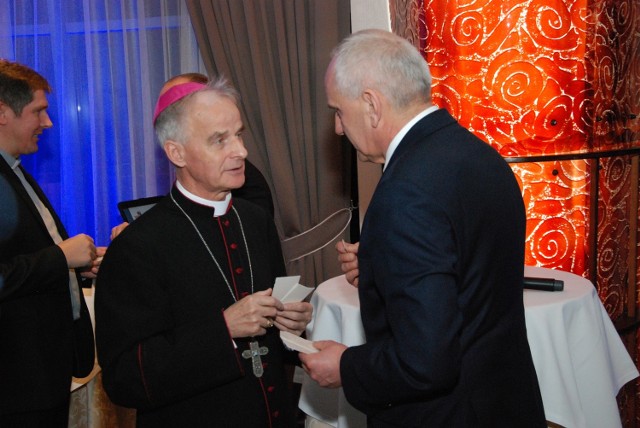 Opłatkiem łamią się Mirosław Malinowski i ksiądz biskup Marian Florczyk.