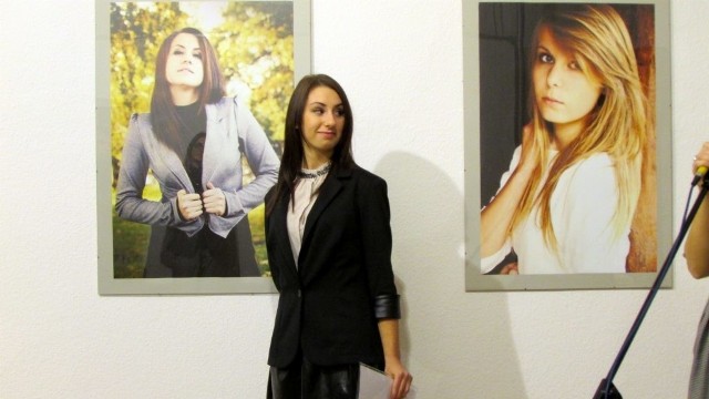 Aleksandra Zdanowska na tle swoich prac podczas wystawy w ośrodku kultury.