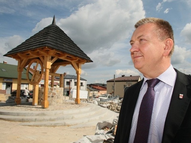 Burmistrz Robert Jaworski przed wyremontowaną studnią na rynku.
