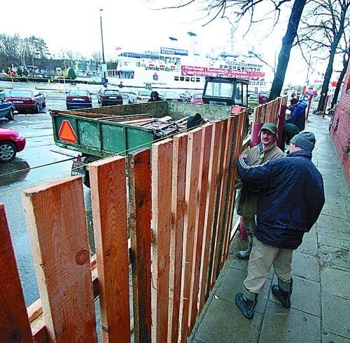 Płot zabezpieczający budowę przy ul. Portowej jest już niemal całkiem postawiony. Będzie się ciągnął aż pod Bulwar Szymańskiego. &#8211; Budki handlarzy można przenieść, ale co zrobić ze statkami pasażerskimi i sklepami? &#8211; pytają pracujący na placu ludzie.