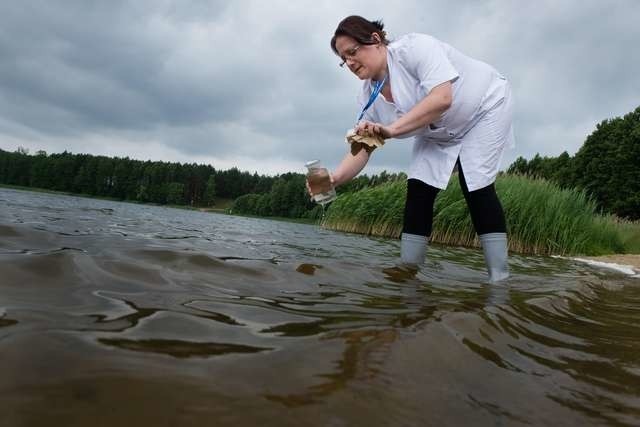 Magdalena Ossowska z laboratorium Toruńskich Wodociągów pobiera próbki wody z jeziora w Osieku