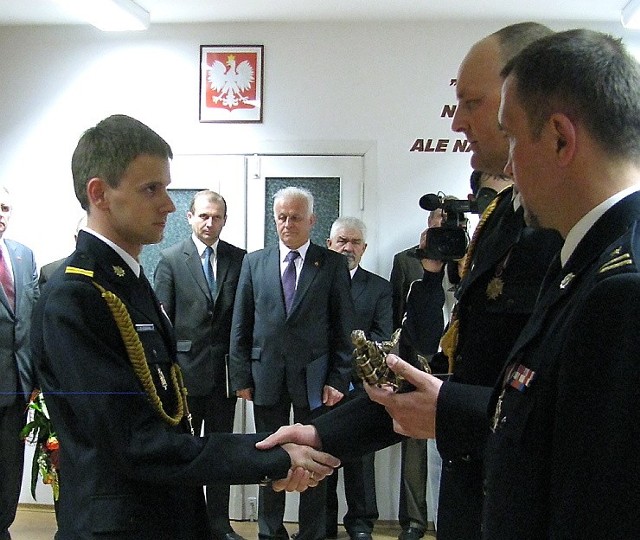 Robert Stasiak pamiątkową statuetkę odebrał od bryg. Sławomira Herbowskiego i mł.bryg. Andrzeja Kujaczyńskiego 