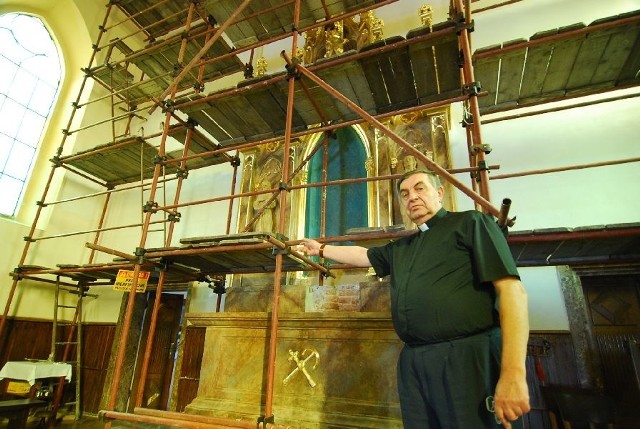 Ksiądz Roman Stępień, proboszcz parafii Świętego Mikołaja w Baćkowicach pokazuje ołtarz główny, po bokach którego niegdyś stały drewniane rzeźby. Po konserwacji rzeźby powrócą na swoje miejsce.