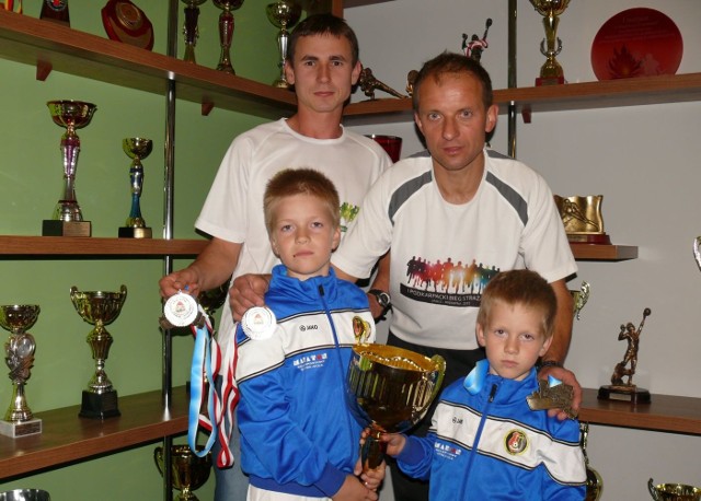 Krzysztof Krawczyk (z prawej) z synami trzymającymi puchar, obok Paweł Kurkiewicz.