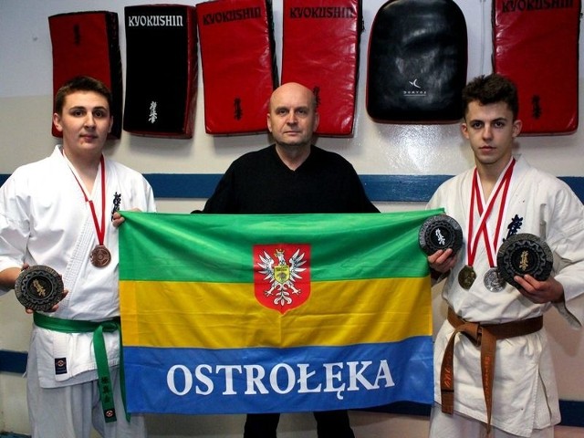 Adrian Kaliszewski, sensei Wiesław Orzoł i Michał Zysk dumnie prezentują trofea.