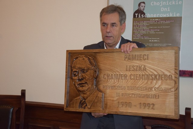 Burmistrz Arseniusz Finster pokazuje tablicę upamiętniającą pierwszego burmistrza Leszka Chamier-Cieminskiego