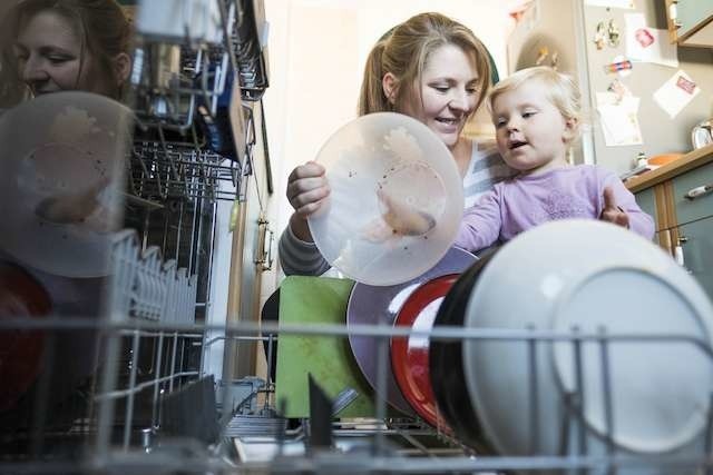 Podwyżki cen wody, śmieci, energię,Pani Marta z córką Agatką wstawiają naczynia do mycia w zmywarce