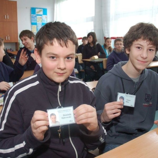 Dominik Dąbrowski i Victor Hinz z klasy Ik z Publicznego Gimnazjum numer 13 w Radomiu prezentują swoje identyfikatory, które uczniowie noszą, jako uzupełnienie stroju szkolnego.
