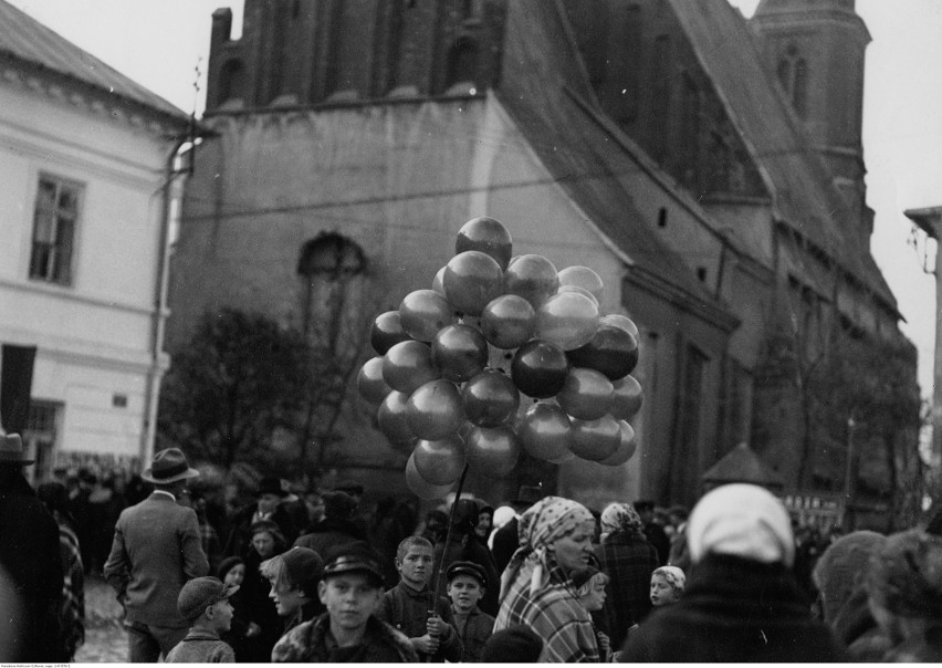 Uczestnicy odpustu wśród straganów odpustowych. Na drugim...