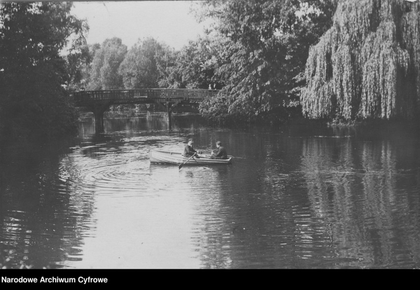 Mostek na stawie. Mieszkańcy pływają w kajakach. Rok 1926....