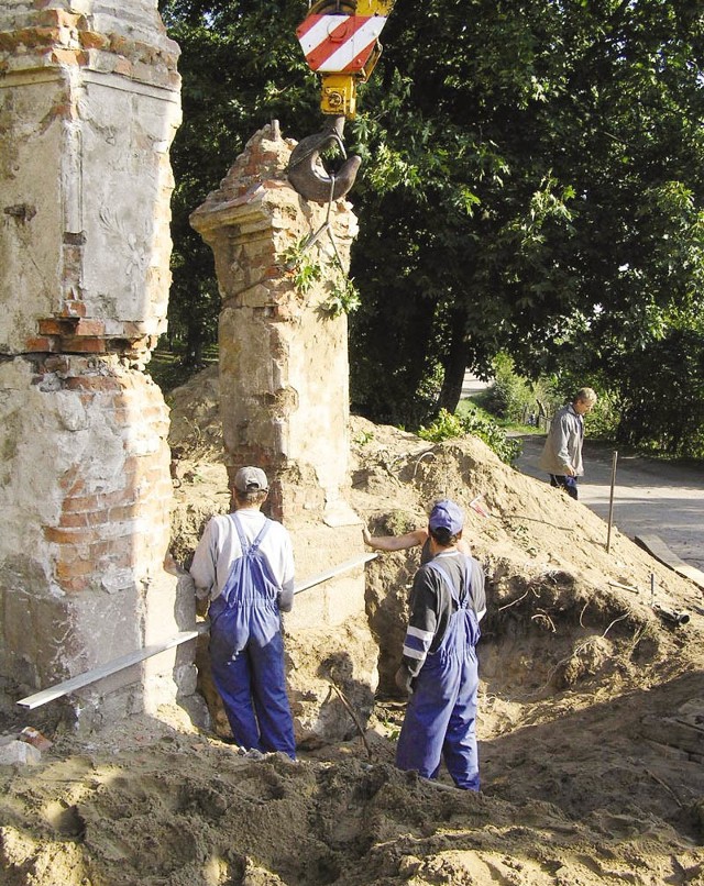 Pracownicy interwencyjni ustawili już fragmenty dawnych filarów, podtrzymujących bramę wjazdową na cmentarz przy ulicy Miłej w Bytowie.