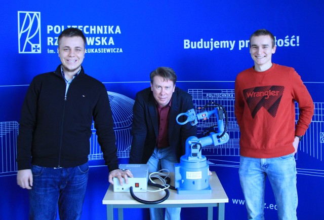 Studenci Łukasz Kapała i Aleksander Janeczko ze swoim opiekunem naukowym przy robocie