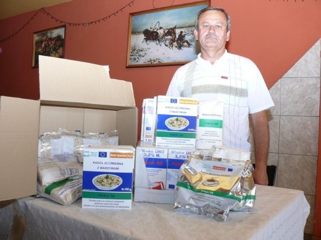 Zdzisław Pańtak, prezes stowarzyszenia z Sobkowa, prezentuje porcje żywnościowe, jakie dostawał każda osoba podczas ostatniej dostawy.