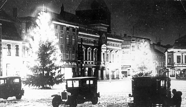 W ramach przedświątecznego klimatu -  który z dnia na dzień czuć coraz mocniej -  przygotowaliśmy kilka pięknych fotografii, na których możemy zobaczyć dawny, świąteczny Koszalin oraz to, jak ówcześni koszalinianie korzystali z zimowej aury. Zdradzamy też, jak wtedy wyglądały przygotowania do Bożego Narodzenia  i jego świętowanie.   Jak widać na zdjęciach nie tylko współcześni mieszkańcy Koszalina lubią, aby w czasie Świąt Bożego Narodzenia nie tylko domy i mieszkania nabrały świątecznego charakteru, ale również miasto, w którym przyszło im żyć. Na jednym i drugim zdjęciu - których autorzy uwiecznili w latach 30. ubiegłego wieku dworzec kolejowy oraz fragment koszalińskiego rynku - możemy zobaczyć, że ówcześni mieszkańcy dbali o niepowtarzalny, bożonarodzeniowy klimat. Szczególnie piękne jest zdjęcie z dwiema oświetlonymi choinkami ustawionymi w pobliżu ratusza. W tamtym czasie miejski magistrat znajdował się właśnie na samym rogu rynku w budynku, w miejscu  którego znajduje się dziś przy ulicy Zwycięstwa filia Banku Pekao SA (wcześniej przez wiele lat funkcjonował tutaj sklep jubilerski).