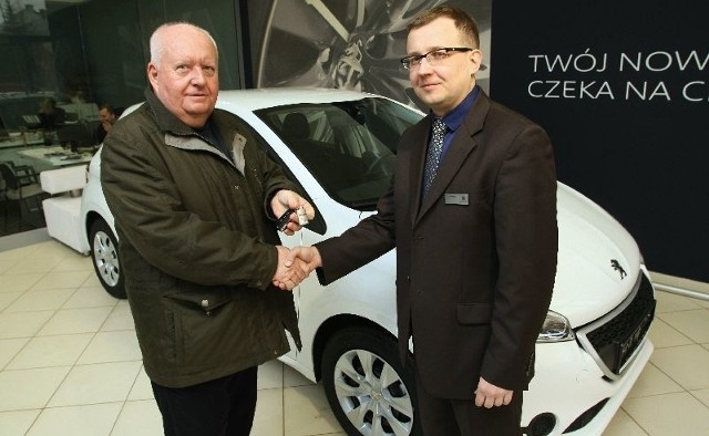 Piotr Jaworski składa na ręce pana Marka gratulacje i&#8230; kluczyki do nowego peugeota. Nasz czytelnik odebrał w czwartek auto w salonie Peugeota w Kielcach.