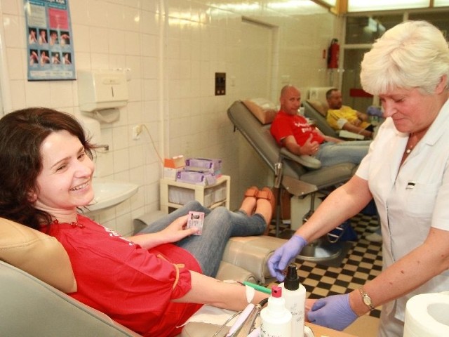 Specjalista Anna Głowacka pobiera krew od Beaty Nowak, w głębi zdjęcia marszałkowski dawca Rafał Szymkiewicz.