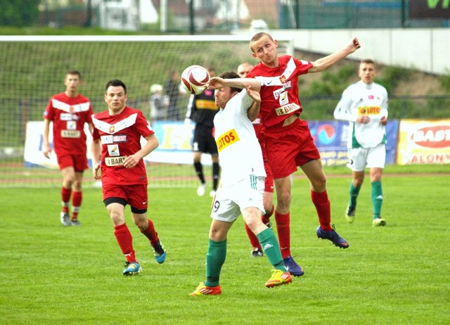 Powietrzny pojedynek o piłkę Łukasza Wenerskiego (czerwony strój) i Jakuba Wilka