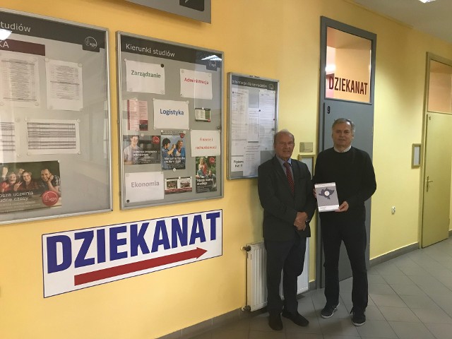 Prof. Robert Rauze Rauziński oraz prorektor dr Tadeusz Pokusa pokazują najnowszą publikację uczelni.
